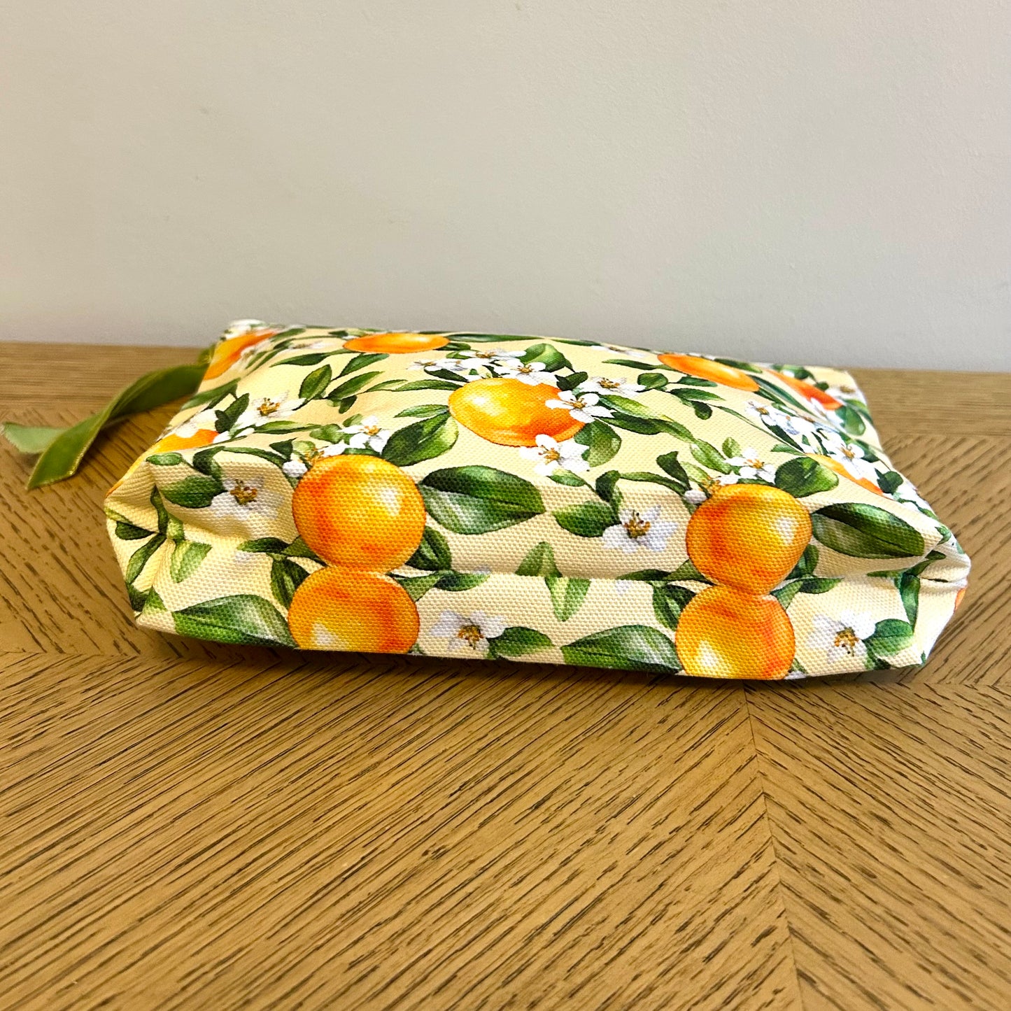 tiletry bag in orange blossom print showing 4 cm wide gusset base.