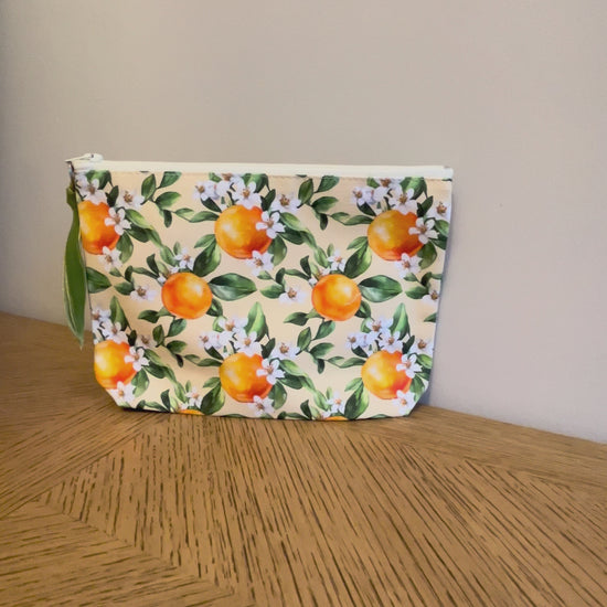 Cosmetic toiletry bag with an orange blossom print lined with a zip and gusset. :Labelled Made in the UK